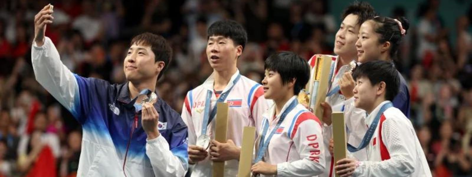 North and South Korean athletes share an Olympic podium — and take a selfie